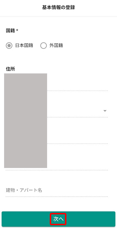 基本情報の登録画面（国籍の選択および住所・建物名の入力フォームと「次へ」ボタンの強調）